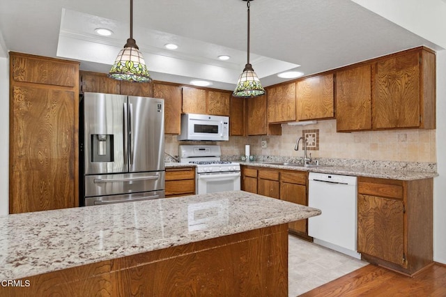 27127 Rio Bosque Dr, Valencia, CA 91354 - kitchen featuring white appliances, a raised ceiling, brown cabinetry, tasteful backsplash, and recessed lighting