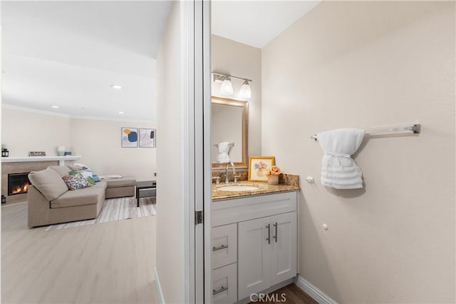 150 Diamond St Unit B, Arcadia, CA 91006 - bathroom with vanity, ornamental molding, a warm lit fireplace, wood finished floors, and recessed lighting