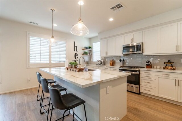 1827 Montecito Ln, Redlands, CA 92374 - kitchen featuring stainless steel appliances, backsplash, white cabinets, light wood-style flooring, and recessed lighting