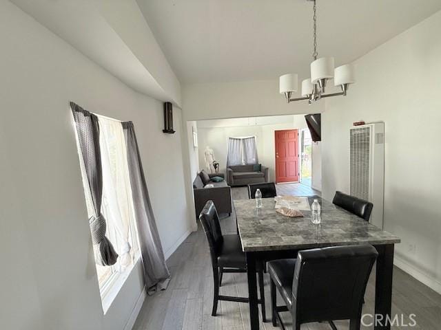 647 E 38th St, Los Angeles, CA 90011 - dining area featuring a chandelier, wood finished floors, and a heating unit