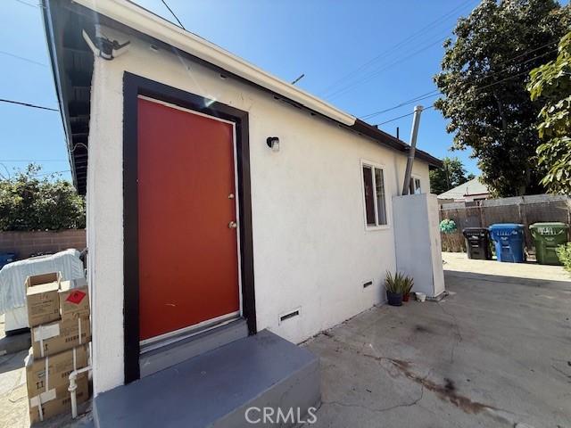 647 E 38th St, Los Angeles, CA 90011 - property entrance with stucco siding, a patio, and crawl space