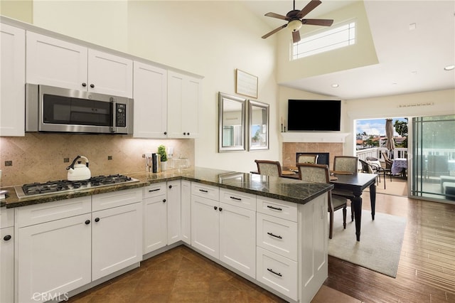 806 N Irena Ave Unit A, Redondo Beach, CA 90277 - kitchen featuring stainless steel appliances, a peninsula, a ceiling fan, a towering ceiling, and white cabinetry