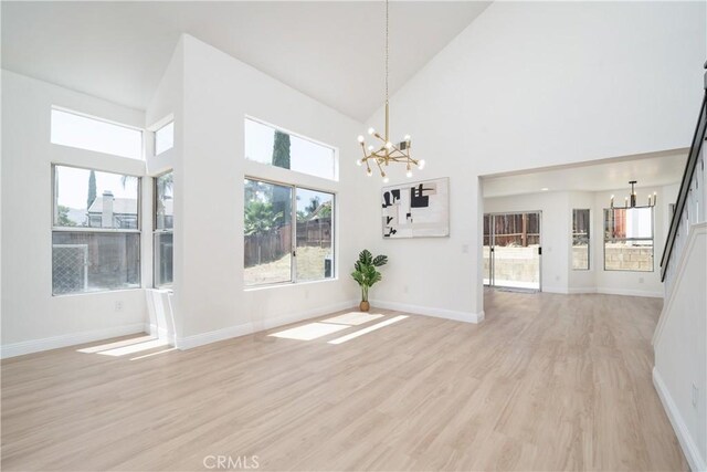 23760 Timber Bluff Ct, Moreno Valley, CA 92557 - unfurnished dining area featuring a chandelier, light wood-style flooring, and high vaulted ceiling