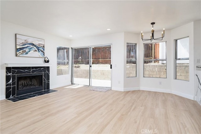 23760 Timber Bluff Ct, Moreno Valley, CA 92557 - unfurnished living room with a chandelier, wood finished floors, a high end fireplace, and recessed lighting