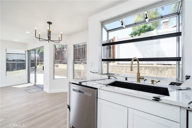23760 Timber Bluff Ct, Moreno Valley, CA 92557 - kitchen with dishwasher, a chandelier, light stone countertops, light wood-style flooring, and white cabinetry
