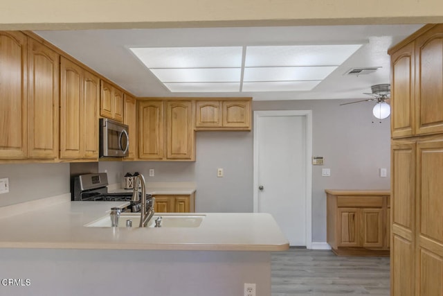 4062 Bridgewood Ln, Thousand Oaks, CA 91362 - kitchen with stainless steel appliances, a peninsula, light wood finished floors, light countertops, and ceiling fan