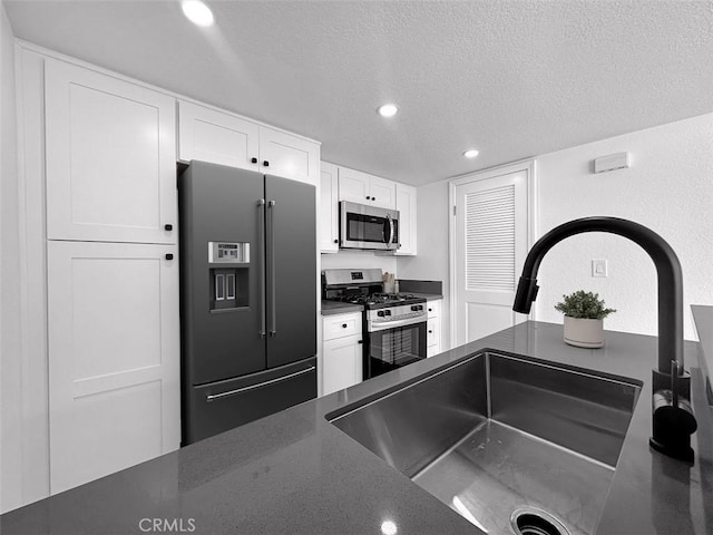 17333 Brookhurst St Unit D6, Fountain Valley, CA 92708 - kitchen with appliances with stainless steel finishes, dark countertops, white cabinets, a textured ceiling, and recessed lighting