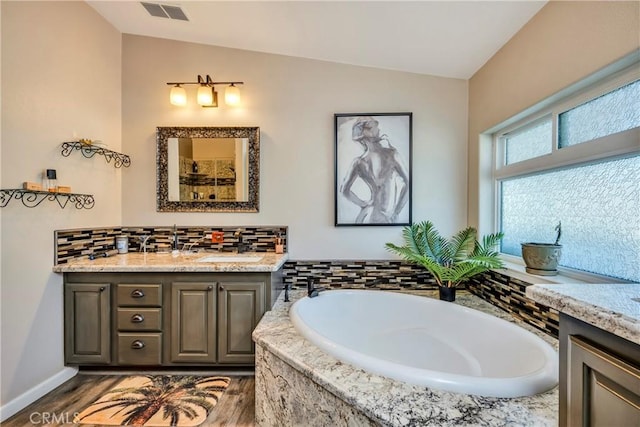 17432 Sendero Way, Lower Lake, CA 95457 - bathroom featuring vanity, a garden tub, wood finished floors, lofted ceiling, and tasteful backsplash