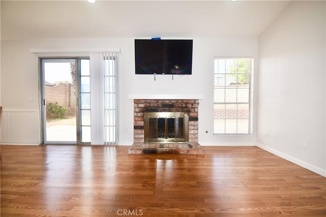 22692 Abington Pl, Moreno Valley, CA 92553 - unfurnished living room featuring wood finished floors, a glass covered fireplace, and vaulted ceiling