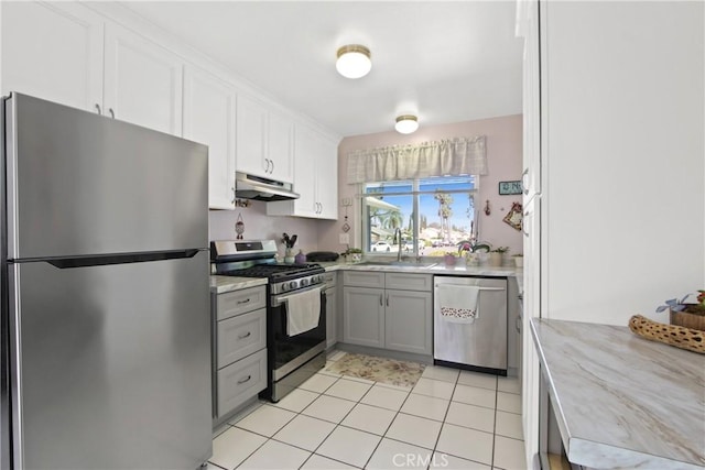 23011 Aspan St, Lake Forest, CA 92630 - kitchen featuring appliances with stainless steel finishes, under cabinet range hood, gray cabinetry, white cabinetry, and light stone countertops