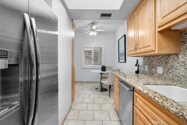 14844 Dickens St Unit 208, Sherman Oaks, CA 91403 - kitchen featuring stainless steel appliances, decorative backsplash, light stone counters, ceiling fan, and light brown cabinetry