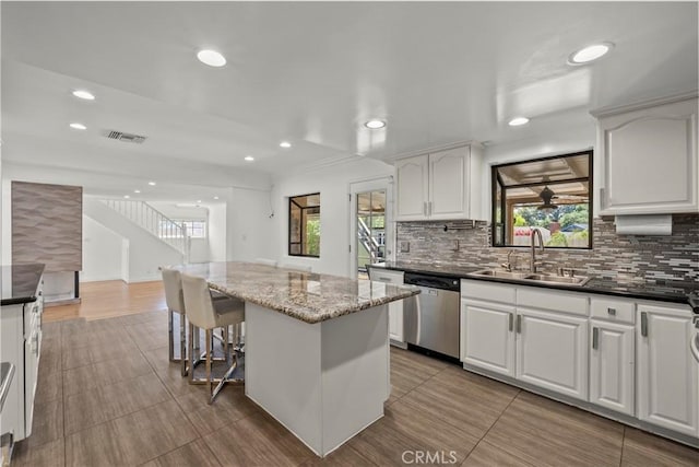 4919 Dunsmore Ave, La Crescenta, CA 91214 - kitchen with dishwasher, a center island, decorative backsplash, recessed lighting, and white cabinetry