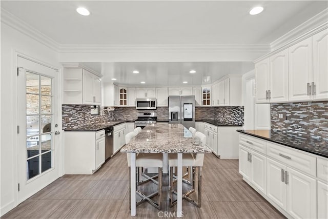 4919 Dunsmore Ave, La Crescenta, CA 91214 - kitchen with stainless steel appliances, glass insert cabinets, a breakfast bar area, white cabinets, and dark stone countertops