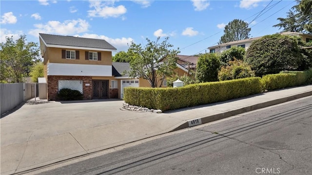 4919 Dunsmore Ave, La Crescenta, CA 91214 - view of front of home featuring driveway, an attached garage, stucco siding, brick siding, and a gate