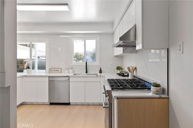 2321 W 182nd St, Torrance, CA 90504 - kitchen featuring appliances with stainless steel finishes, range hood, white cabinets, light wood-style floors, and plenty of natural light