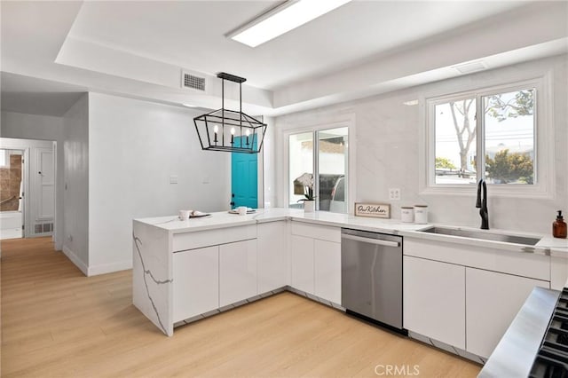 2321 W 182nd St, Torrance, CA 90504 - kitchen featuring stainless steel dishwasher, white cabinets, light wood finished floors, and a peninsula