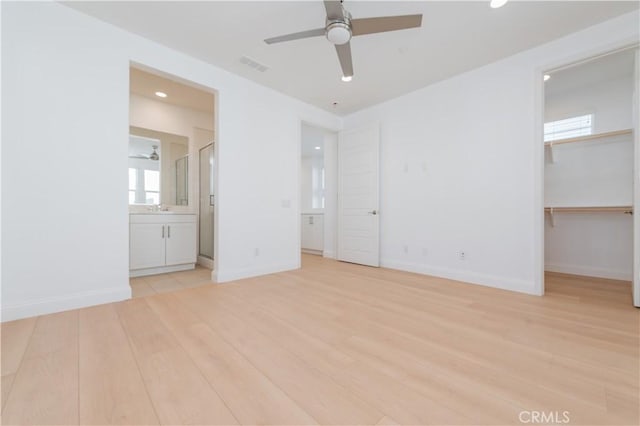 9570 Bluewater Pl, Rancho Cucamonga, CA 91730 - unfurnished bedroom with light wood finished floors, a walk in closet, recessed lighting, and multiple windows