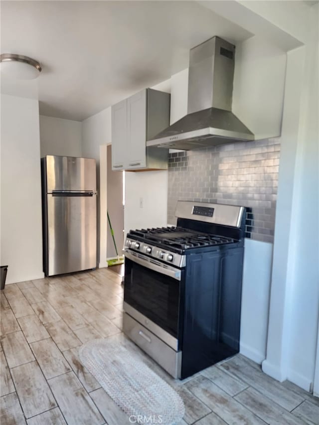 4312 Walton Ave, Los Angeles, CA 90037 - kitchen with stainless steel appliances, wall chimney exhaust hood, light wood finished floors, and decorative backsplash