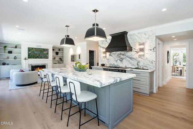 1036 S Madison Ave, Pasadena, CA 91106 - kitchen with custom range hood, light wood-style floors, ornamental molding, a large island, and a kitchen bar