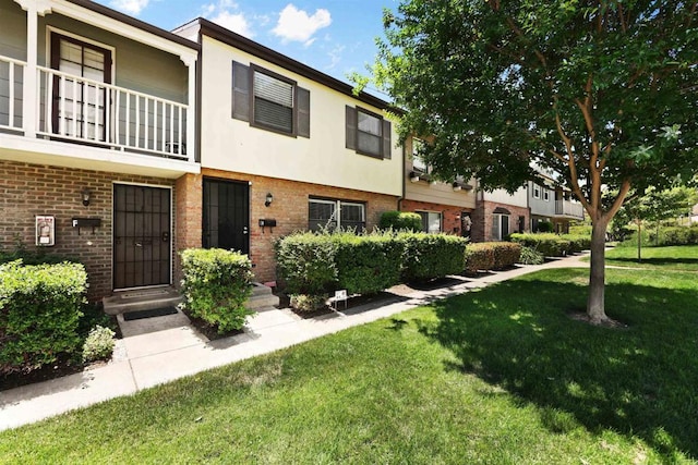 11935 Royal Rd Unit E, El Cajon, CA 92021 - view of front of house with a front lawn, brick siding, stucco siding, and a balcony