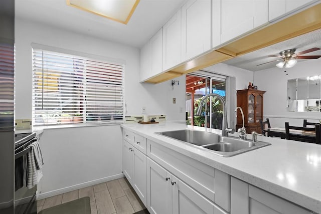 11935 Royal Rd Unit E, El Cajon, CA 92021 - kitchen with electric range, light countertops, light wood-style floors, a ceiling fan, and white cabinetry