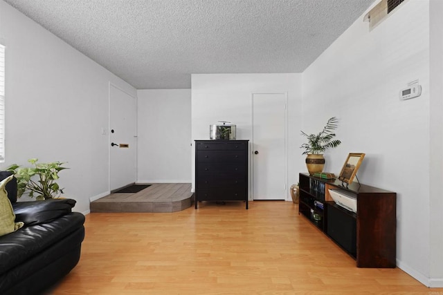 11935 Royal Rd Unit E, El Cajon, CA 92021 - living area featuring light wood-style floors and a textured ceiling
