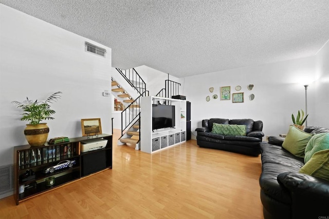 11935 Royal Rd Unit E, El Cajon, CA 92021 - living room featuring stairway, wood finished floors, and a textured ceiling