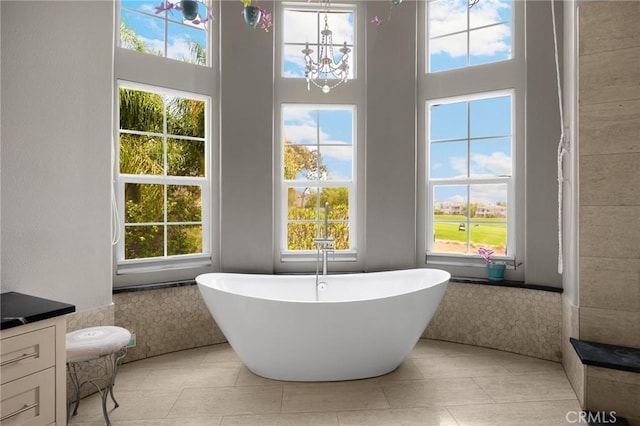 17286 Coriander Ct, Yorba Linda, CA 92886 - bathroom featuring a freestanding bath, healthy amount of natural light, a chandelier, tile patterned flooring, and a high ceiling