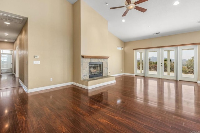 14694 Chaparral Slope Rd, Jamul, CA 91935 - unfurnished living room with high vaulted ceiling, a ceiling fan, wood finished floors, a tiled fireplace, and french doors