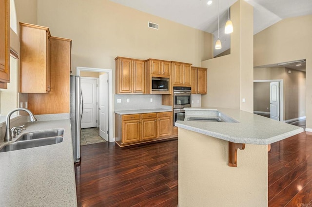 14694 Chaparral Slope Rd, Jamul, CA 91935 - kitchen featuring high vaulted ceiling, appliances with stainless steel finishes, dark wood-type flooring, light countertops, and a breakfast bar area