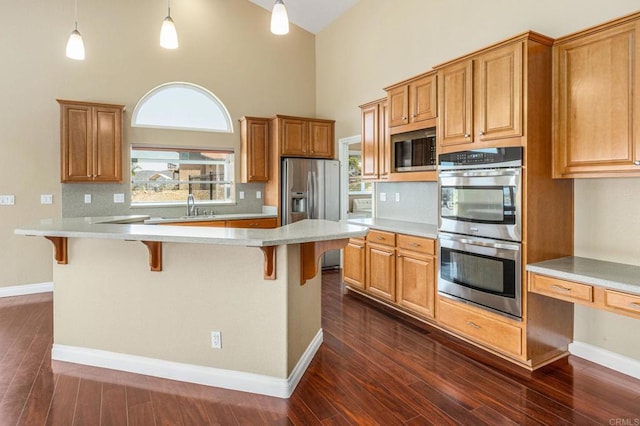 14694 Chaparral Slope Rd, Jamul, CA 91935 - kitchen featuring stainless steel appliances, high vaulted ceiling, dark wood finished floors, a kitchen breakfast bar, and light countertops