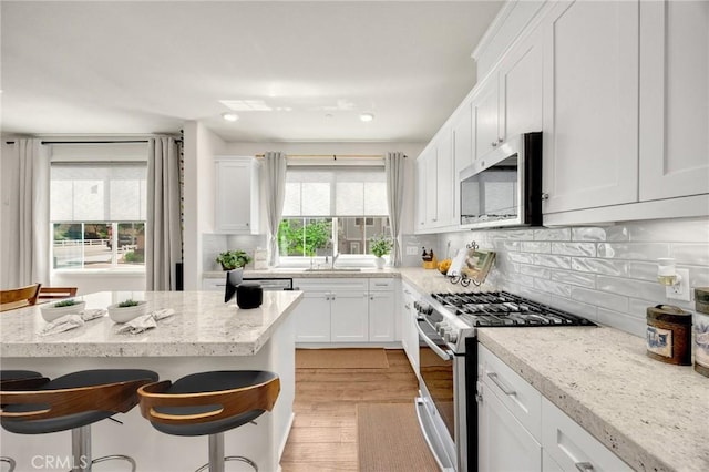 18361 Iris Ln, Yorba Linda, CA 92886 - kitchen featuring stainless steel appliances, a breakfast bar area, white cabinetry, and recessed lighting