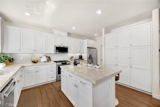18361 Iris Ln, Yorba Linda, CA 92886 - kitchen with stainless steel appliances, wood finished floors, white cabinets, tasteful backsplash, and recessed lighting