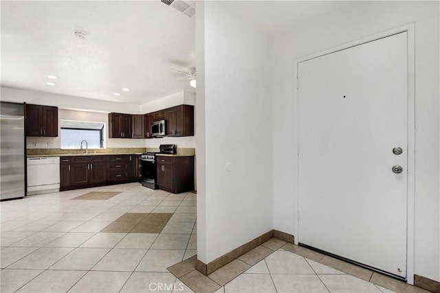 24409 Dunlavy Ct, Moreno Valley, CA 92557 - kitchen with stainless steel appliances, dark brown cabinetry, light tile patterned floors, light countertops, and ceiling fan