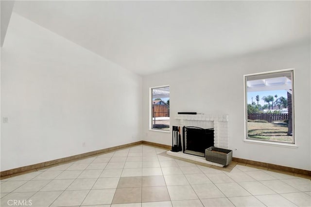 24409 Dunlavy Ct, Moreno Valley, CA 92557 - unfurnished living room featuring a brick fireplace, light tile patterned floors, and lofted ceiling