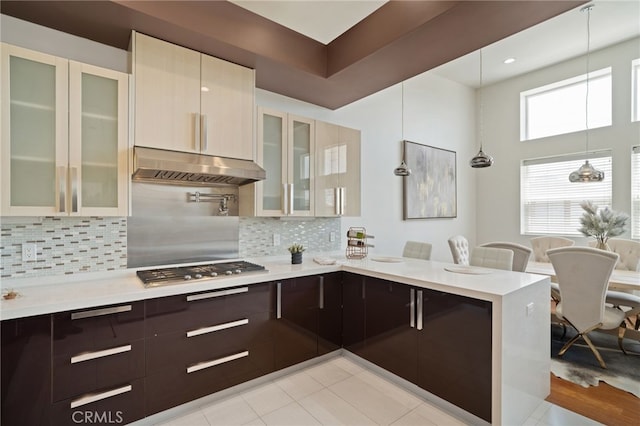 2623 Carnegie Ln, Redondo Beach, CA 90278 - kitchen featuring under cabinet range hood, stainless steel gas cooktop, dark brown cabinetry, a peninsula, and modern cabinets