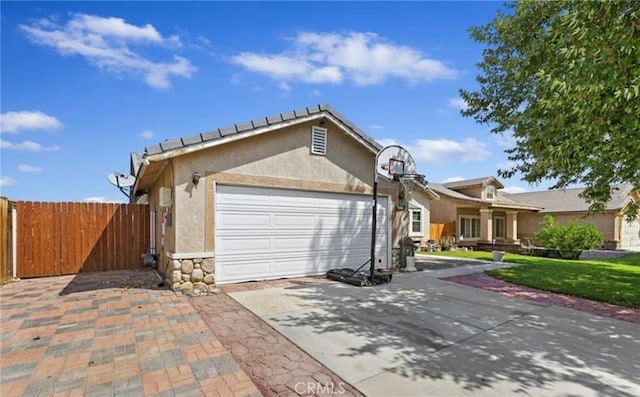 10982 Sherman Way, Adelanto, CA 92301 - view of front facade featuring a garage, stucco siding, driveway, and stone siding