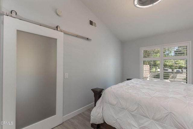 5684 Recodo Way, Camarillo, CA 93012 - bedroom featuring lofted ceiling, wood finished floors, and a barn door