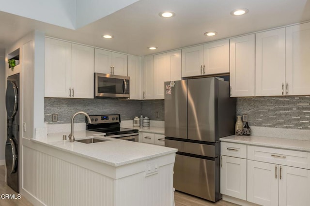 5684 Recodo Way, Camarillo, CA 93012 - kitchen featuring appliances with stainless steel finishes, light countertops, a peninsula, backsplash, and white cabinetry