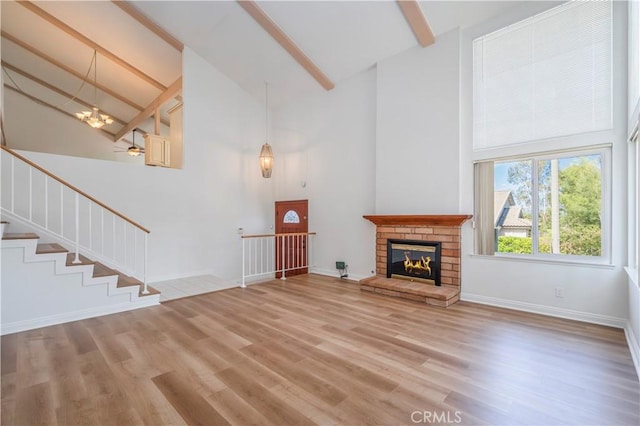 2239 Maystone Pl, Rowland Heights, CA 91748 - unfurnished living room with high vaulted ceiling, beamed ceiling, light wood-style flooring, a glass covered fireplace, and a chandelier