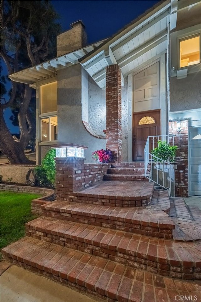 2239 Maystone Pl, Rowland Heights, CA 91748 - exterior entry at night featuring stucco siding and a chimney