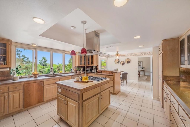 4678 Sun Vly, Del Mar, CA 92014 - kitchen featuring a raised ceiling, light tile patterned floors, island exhaust hood, a kitchen island, and glass insert cabinets