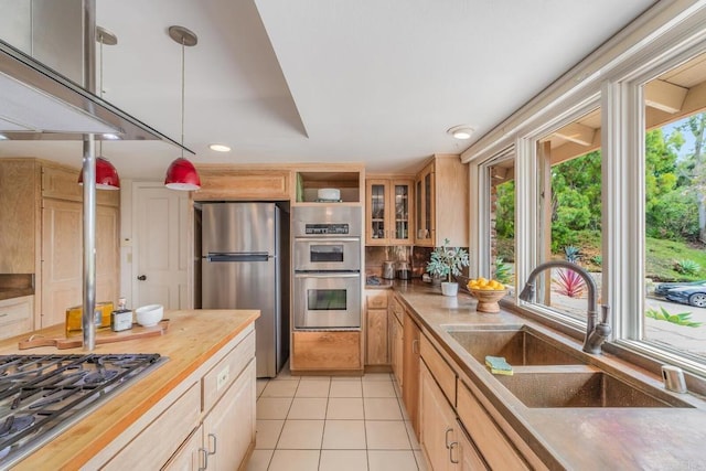4678 Sun Vly, Del Mar, CA 92014 - kitchen with appliances with stainless steel finishes, butcher block counters, light tile patterned flooring, glass insert cabinets, and light brown cabinets