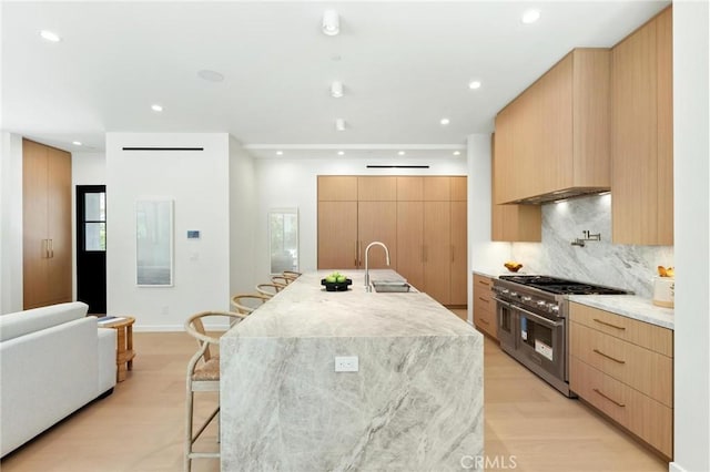 2206 Gates Ave Unit A, Redondo Beach, CA 90278 - kitchen featuring range with two ovens, modern cabinets, a kitchen bar, light wood-style flooring, and tasteful backsplash