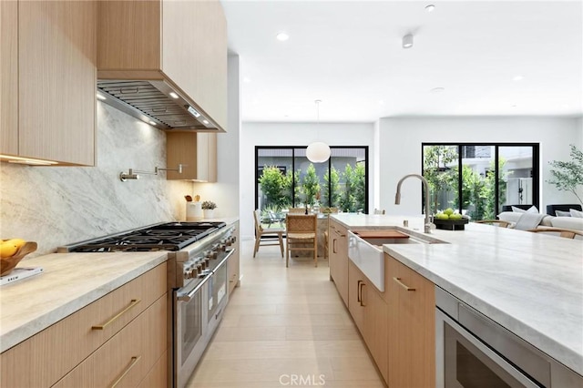 2206 Gates Ave Unit A, Redondo Beach, CA 90278 - kitchen with range with two ovens, light brown cabinetry, modern cabinets, light stone countertops, and premium range hood