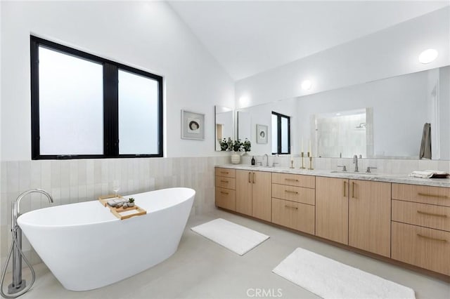 2206 Gates Ave Unit A, Redondo Beach, CA 90278 - bathroom with vaulted ceiling, tile walls, double vanity, a freestanding bath, and a stall shower