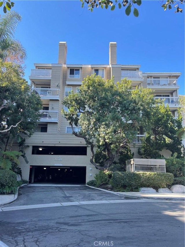 20301 Bluffside Cir Unit D406, Huntington Beach, CA 92646 - view of property featuring an attached garage and driveway