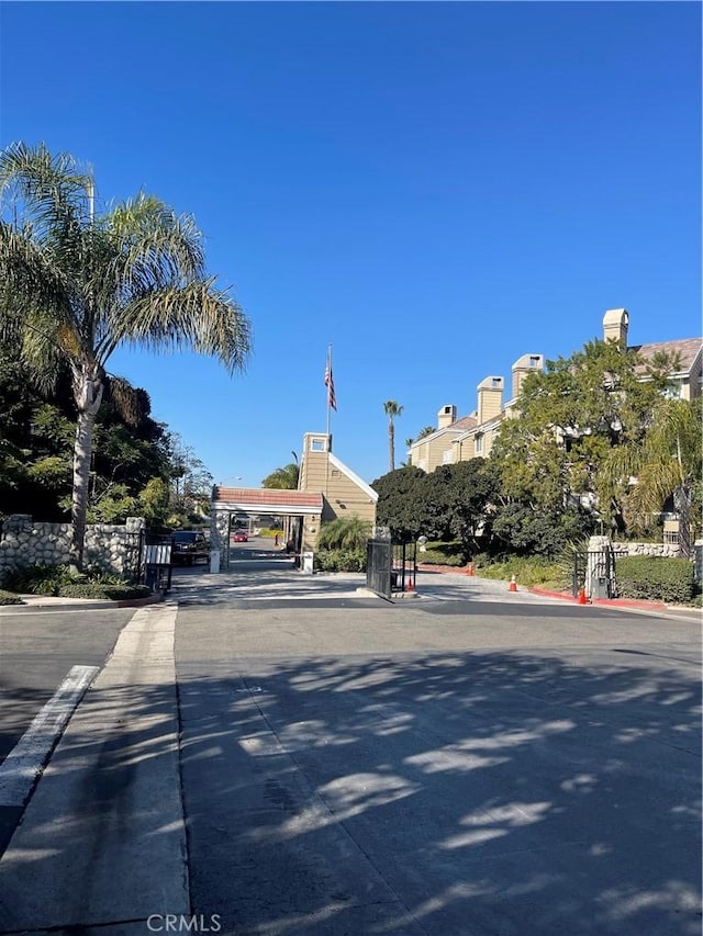 20301 Bluffside Cir Unit D406, Huntington Beach, CA 92646 - view of asphalt road with a gate and curbs