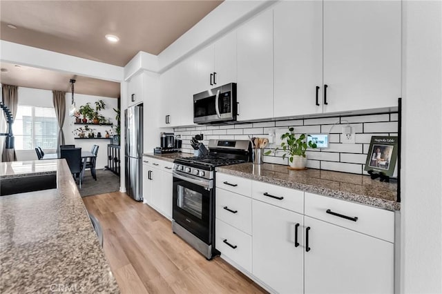 1446 Azalea Cir, Gardena, CA 90247 - kitchen with stainless steel appliances, light wood-style floors, decorative backsplash, white cabinetry, and recessed lighting