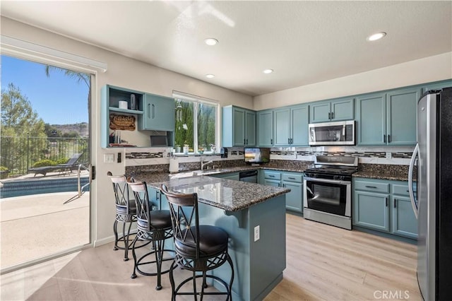 29508 Alyssum Ln, Canyon Country, CA 91387 - kitchen with stainless steel appliances, a peninsula, a breakfast bar, dark stone counters, and recessed lighting